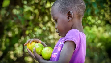 Kamamas Mutter hat dank dem sauberen Wasser eine Obstplantage