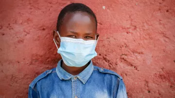 Junge mit Nasen-Mund-Schutz