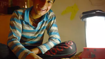 Junge mit Solarlampe aus Indien
