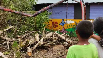 Kinder in Honduras betrachten die durch Hurrican Iota entstandenen Schäden an ihrem Kinderhaus.