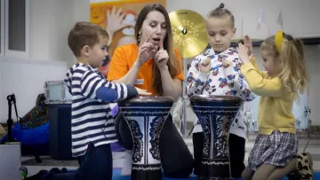 Betreuerin mit geflüchteten ukrainischen Kindern in Georgien