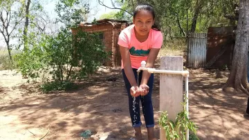 Mädchen vor einem Pumpbrunnen