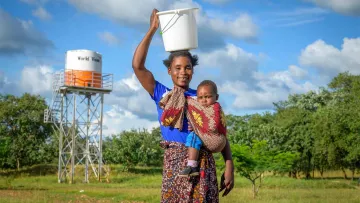 Fraue mit Wassereinmer in Sambia