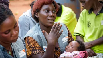 Eine Gesundheitsarbeiterin mit Baby auf dem Arm