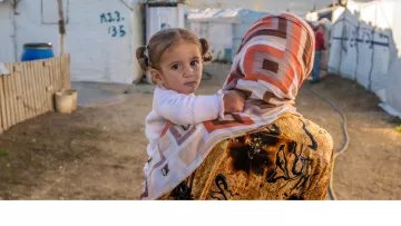 Syrisches Mädchen auf dem Arm ihrer Mutter