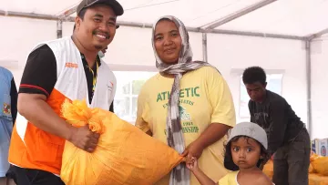 World Vision Mitarbeiter versorgt Familien mit Nothilfegütern