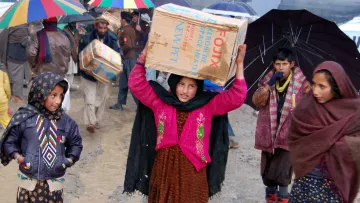 Flüchtlingskind trägt Nothilfepaket