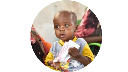 Kleinkind mit Ergänzungsnahrung im Sudan