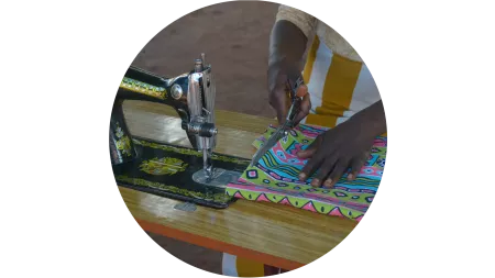 Junge Frau aus dem Südsudan an einer Nähmaschine 