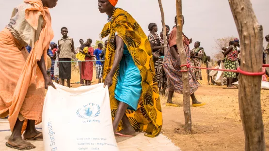 Hunger im Südsudan - Frauen schleppen Säcke mit Getreide von nahrungsmittelverteilung