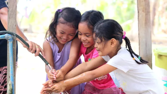 Zugang zu Trinkwasser für drei junge Freundinnen