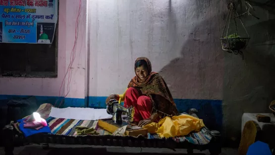 Dank Solarlampen kann diese junge Frau abends noch nähen.