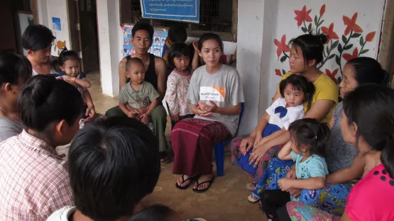 World Vision Mitarbeiterin im Gespräch mit Familien in Myanmar.