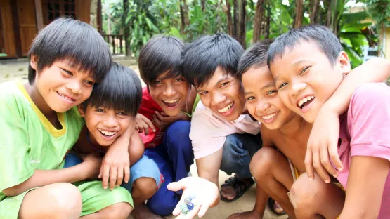 Patenkinder in Vietnam spielen Murmeln.