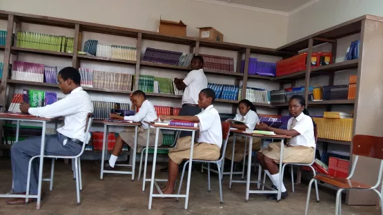 Schulkinder in ihren voll ausgestatteten Klassenzimmern. 