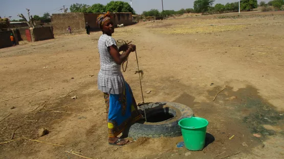 Frau an einer alten Wasserstelle