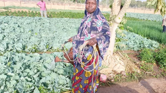 Eine Frau präsentiert stolz ihre Ernte