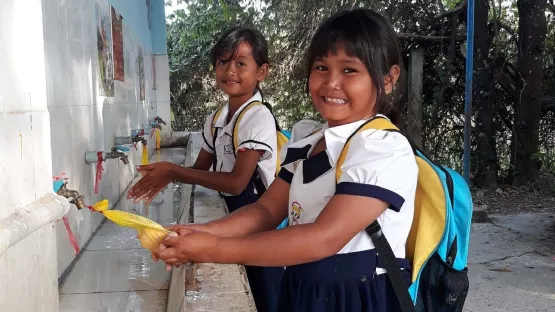 Kinder an einem Waschbacken mit sauberem Wasser