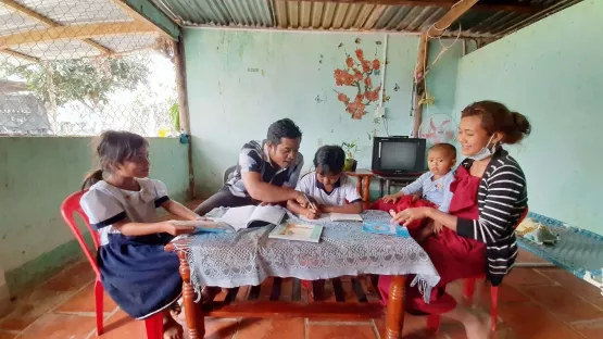 Eltern machen gemeinsam mit ihren Kindern Hausaufgaben