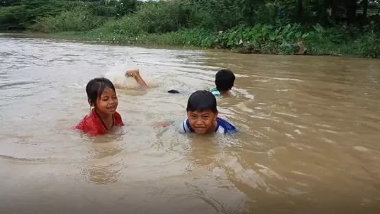 Kinder schwimmen in einem Fluss