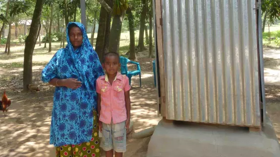 Mutter und ihr Sohn vor einer neuerrichteten Toilette