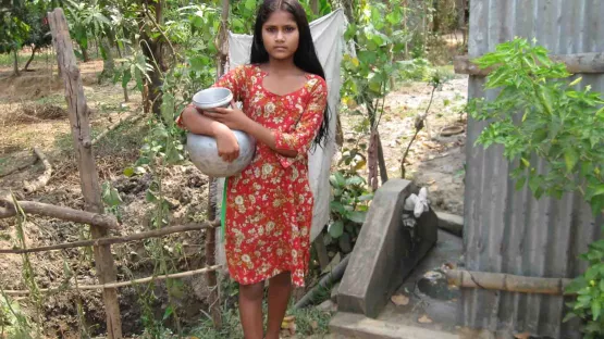 Mädchen muss Wasser mit einem Wassereimer holen