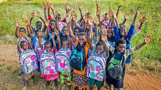 Kinder freuen sich über neue Schulranzen, die sie von World Vision geschenkt bekommen haben