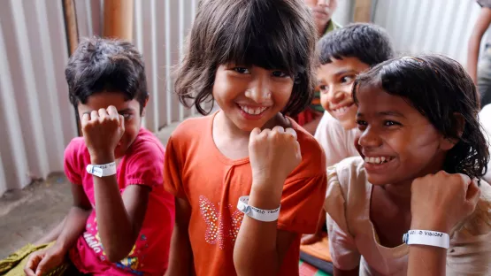 Flüchtlingskinder zeigen ihre neuen Trackingarmbänder