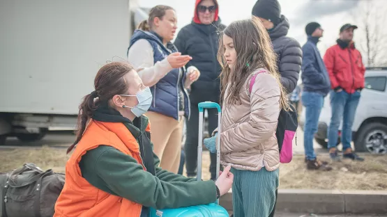 World Vision-Mitarbeiter spricht mit einem Kind aus der Ukraine