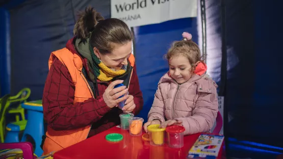 Mitarbeiterin und Kind im World Vision-Spielzelt in Rumänien