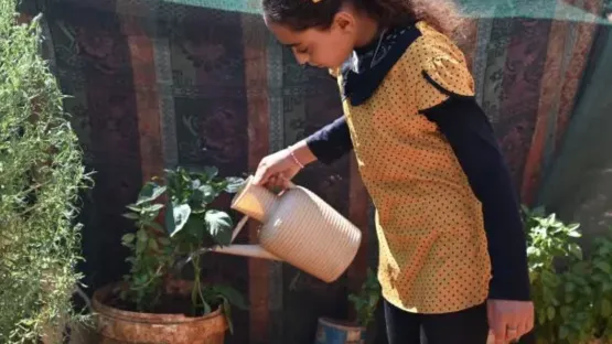 Kind am Wasser gießen